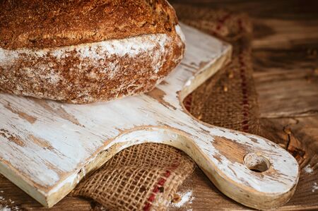 Whole grain home baked bread on rustic wooden backgroundの写真素材
