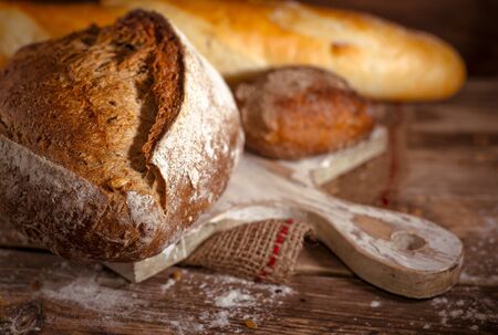 Whole grain home baked bread on rustic wooden backgroundの写真素材