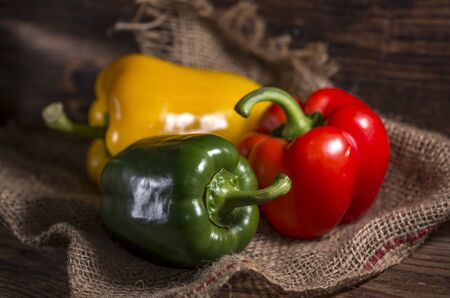 Sweet multicolored peppers on wooden backgroundの写真素材