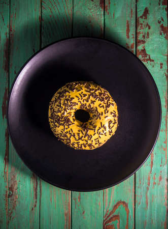 Appetite yellow donut on black plateの写真素材