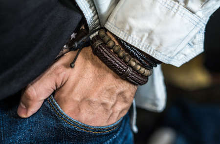 Stylish man wears wrist wooden and leather bracelets