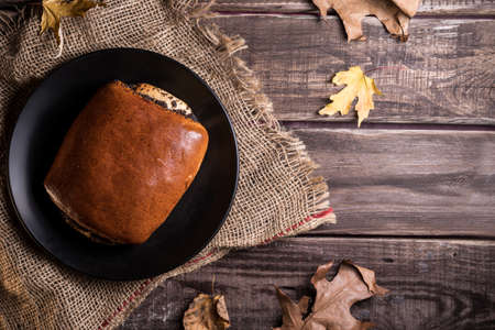 Autumn still life, fresh baked bun on wooden backgroundの写真素材