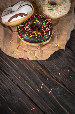 Various fresh baked donuts on a wooden backgroundの写真素材