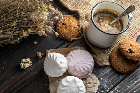 Homemade zephyr, cookies and a cup of coffee on wooden rustic backgroundの写真素材
