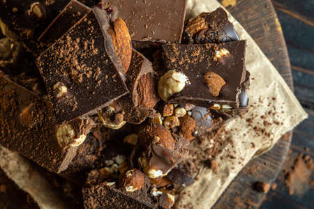 Chopped dark chocolate with hazelnuts on rustic wooden backgroundの写真素材