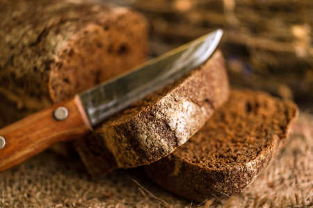 Dark multigrain cereal bread on rustic wooden board
