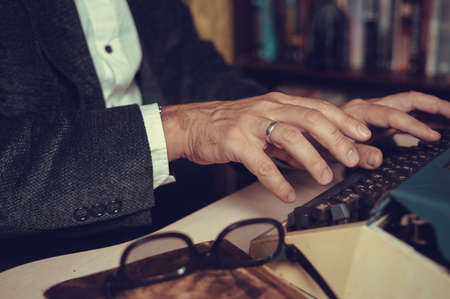 Vintage male writer reporter working behind his deskの写真素材