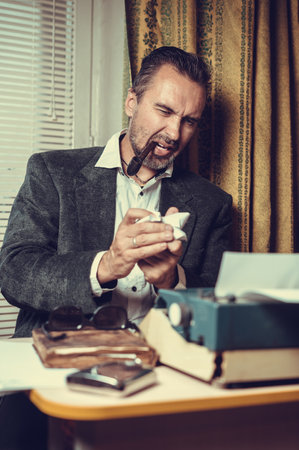Vintage male writer reporter working behind his deskの写真素材