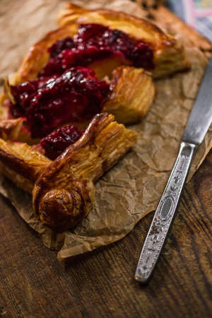 Homemade puff pastry with cherry on old black cooking sheet. Sweet tasty dessert.の写真素材