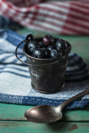 Tiny bucket with blueberries on rustic wooden backgroundの写真素材