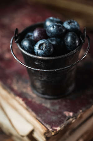 Tiny bucket with blueberries on rustic wooden backgroundの写真素材