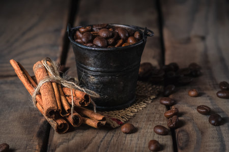 Tiny rusty bucket with coffee beans on rustic wooden backgroundの写真素材