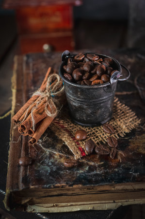 Tiny rusty bucket with coffee beans on rustic wooden backgroundの写真素材