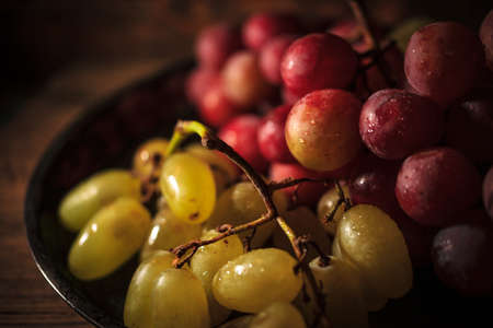 Fresh red and green organic grapes on wooden table, selective focusの写真素材