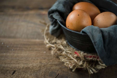 Raw eggs in egg box on rustic wooden backgroundの写真素材