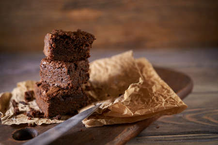 Freshly baked tasty chocolate brownies on a wooden background