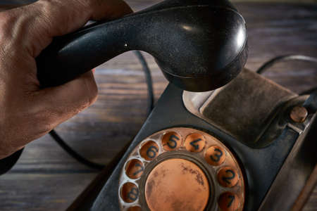 Classic telephone vintage color, dialing or scrolling phone on wooden tableの写真素材