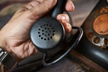 Classic telephone vintage color, dialing or scrolling phone on wooden tableの写真素材