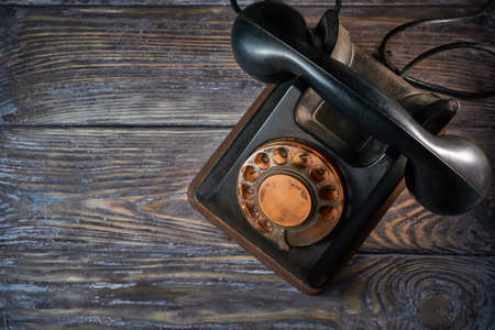 Classic telephone vintage color, dialing or scrolling phone on wooden tableの写真素材