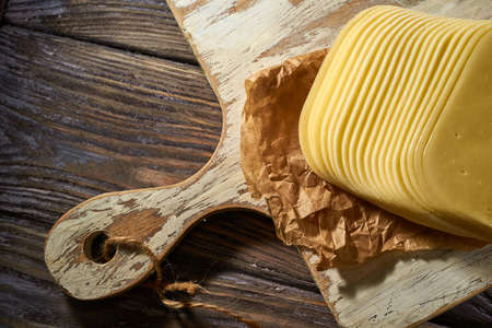 Sliced pieces of cheese on rustic wooden background, cheese sandwichesの写真素材