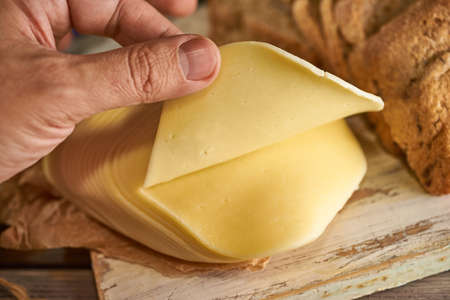 Sliced pieces of cheese on rustic wooden background, cheese sandwichesの写真素材