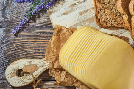 Sliced pieces of cheese on rustic wooden background, cheese sandwichesの写真素材