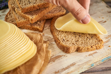 Sliced pieces of cheese on rustic wooden background, cheese sandwichesの写真素材