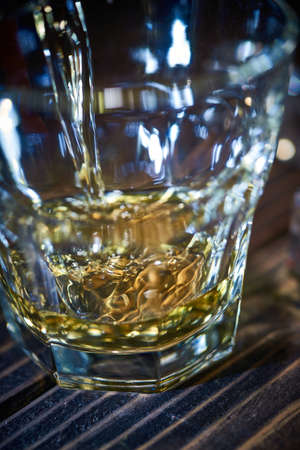 Filled tumbler glass, whisky bar glass, on the rocksの写真素材