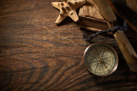 A marine concept with a bottle, starfish, seashells, rope, compass and paper scroll, pirate still lifeの写真素材