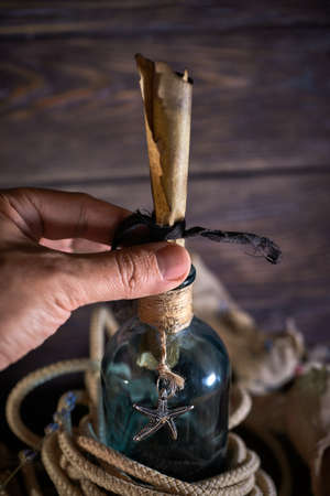 A marine concept with a bottle, starfish, seashells, rope, compass and paper scroll, pirate still lifeの写真素材