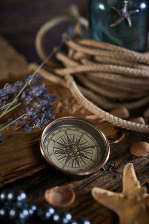 A marine concept with a bottle, starfish, seashells, rope, compass and paper scroll, pirate still lifeの写真素材