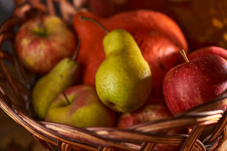 Autumn still life with fruits and vegetables: apples, pears and pumpkin on fallen leaves