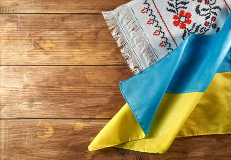 Ukrainian still life with traditional elements: flag of Ukraine, national embroidery and viburnum berries on a wooden backgroundの写真素材