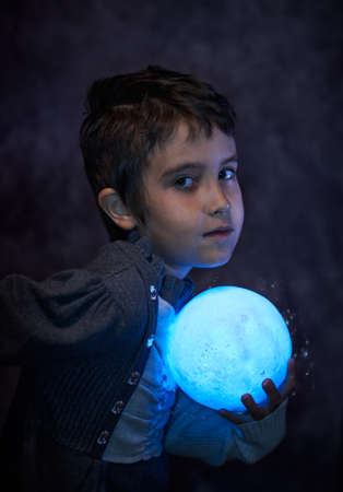 Cute little girl holds the tiny shiny Moonの写真素材