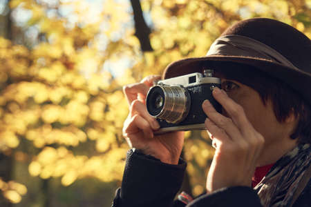 40's old elegant lady using vintage photo camera in the parkの写真素材