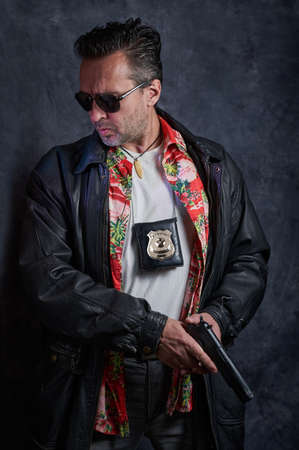 Undercover cop on a dark background, a policeman at work, tough detective, fake badgeの写真素材