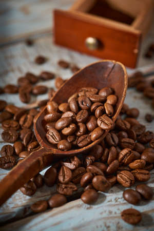 Coffee beans with wooden kitchen accessories on a rustic backgroundの写真素材