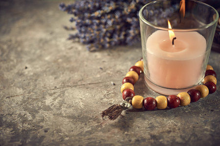 Spiritual still life with candles, beads, and dry flowersの写真素材