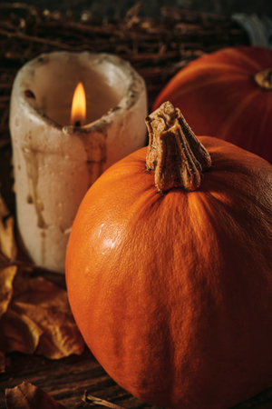 Autumn pumpkins and a candle on a wooden backgroundの写真素材