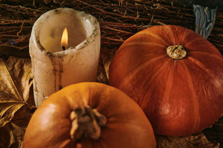 Autumn pumpkins and a candle on a wooden backgroundの写真素材