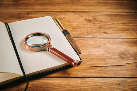 Notebook for daily business notes and magnifying glassの写真素材