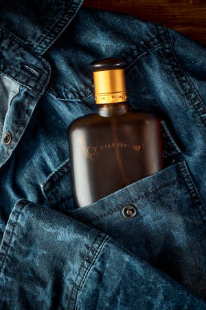 A bottle of perfume for men on denim jeans background, male style, the scent of a manの写真素材