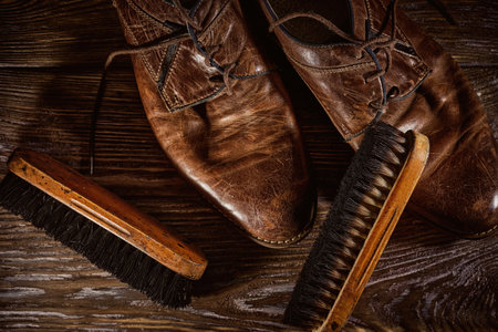 Vintage distressed leather shoes, grunge brown leather boots, rough wooden backgroundの写真素材