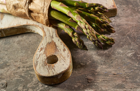 Bunch of fresh green asparagus on a wooden cutting boardの写真素材