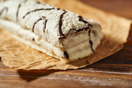 Cake roll with chocolate on a wooden background. Selective focus.の写真素材