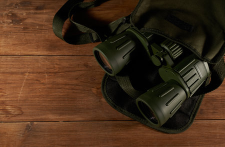Binoculars in a bag on a wooden background. View from aboveの写真素材