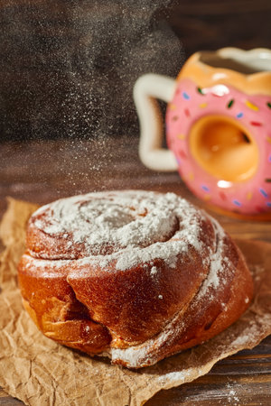 Cinnamon roll with icing sugar on a wooden background. Selective focus.の写真素材