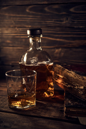 Glass and bottle of whiskey on old wooden background. Toned.の写真素材
