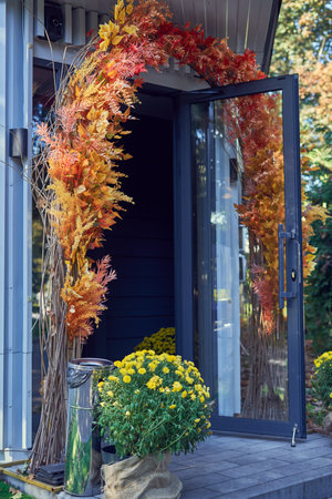 Autumn flowers in front of the door of a modern house.の写真素材