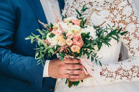 Groom hugs bride. bridal bouquetの写真素材